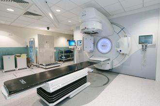Equipamento de radioterapia instalado em uma sala clínica hospitalar para tratamento de pacientes com câncer